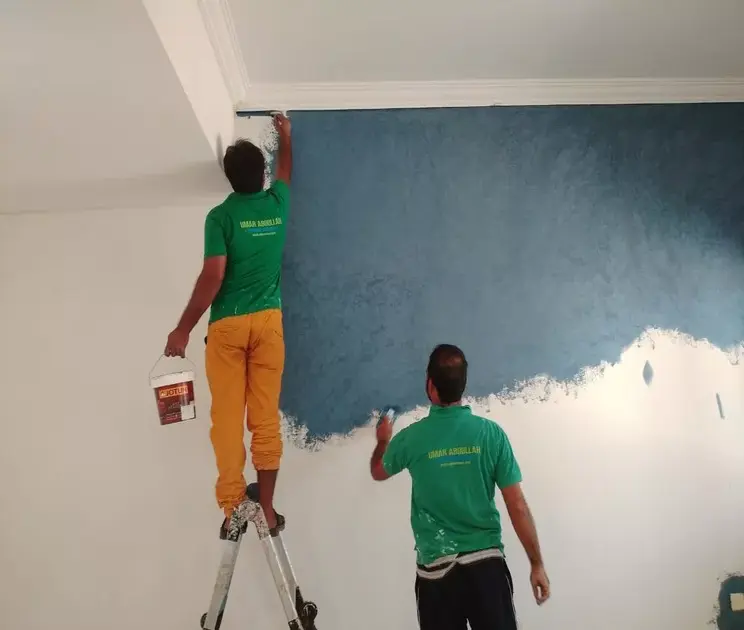 UATS professional painters applying interior wall paint in an Abu Dhabi villa lounge